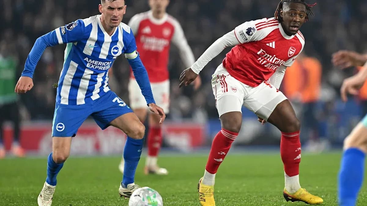 Brighton player challenging Arsenal player for the ball