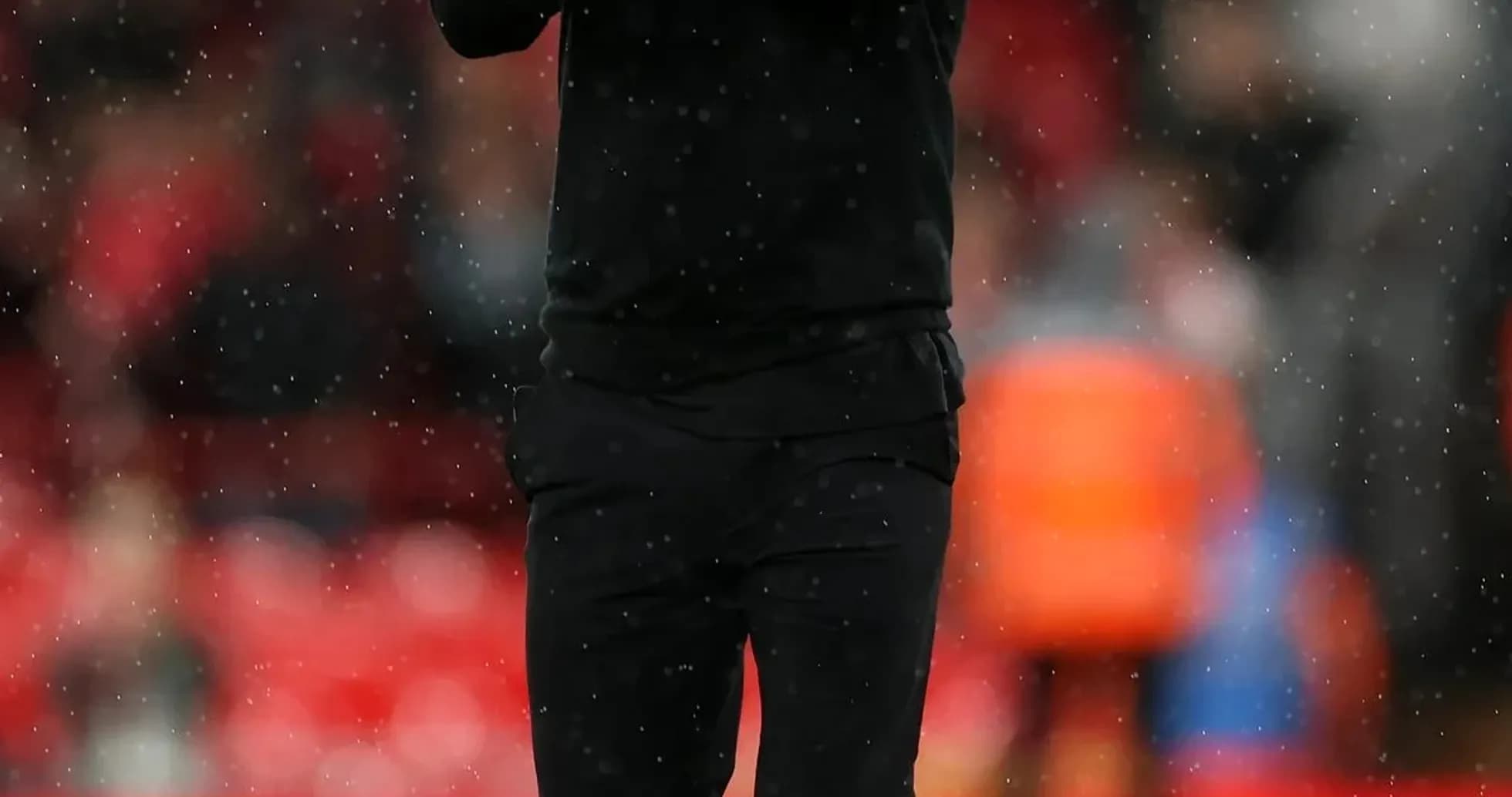 Coach applauding on the pitch during a match