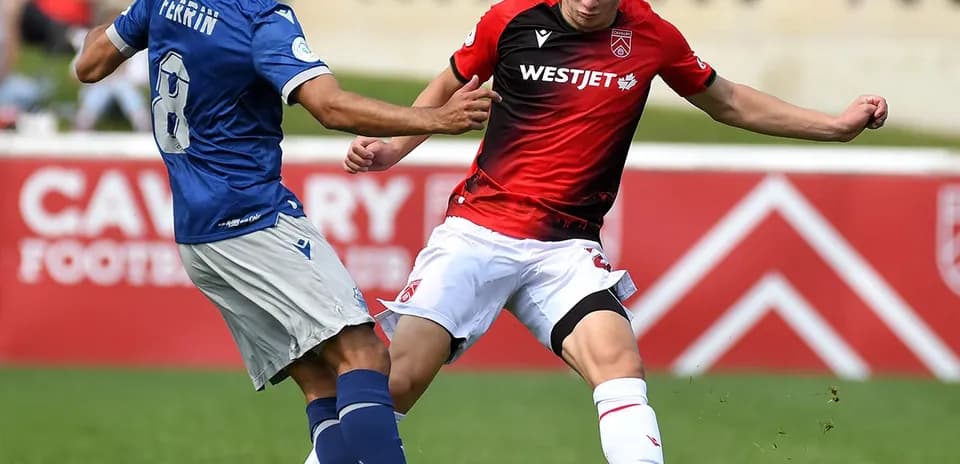 Cavalry FC player tackling HFX Wanderers player