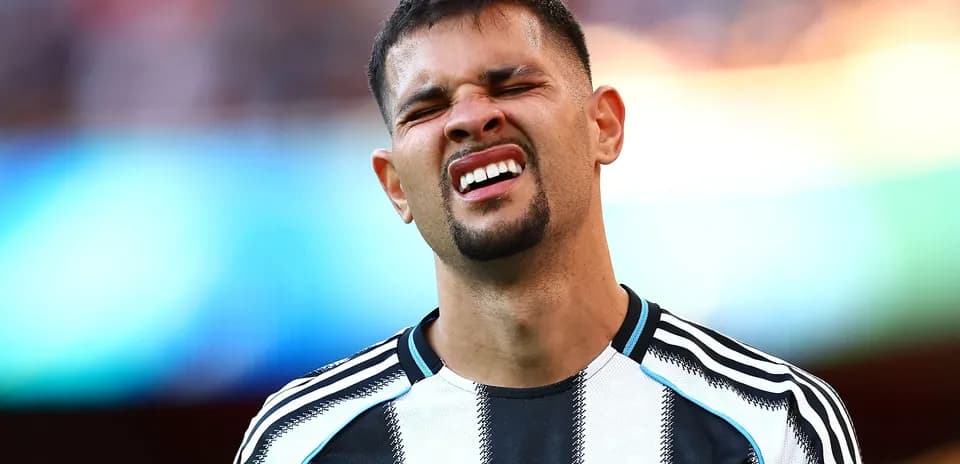 Player grimacing during match with Newcastle kit
