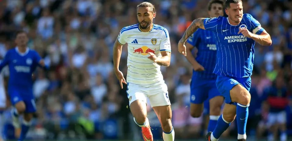 Leeds player sprinting with ball, Brighton defender chasing