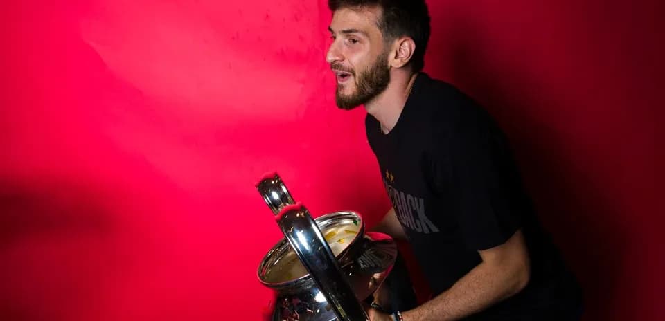 Player celebrating with a trophy against pink backdrop