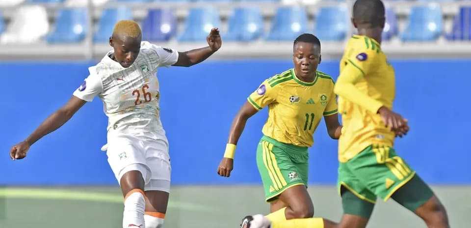 Ivorian player kicking ball against South African opponents