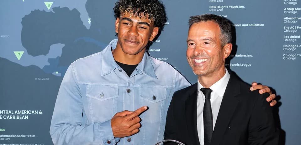 Two men posing with an award at an event