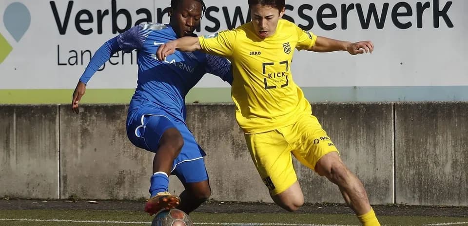 Two players battling for the ball in football match