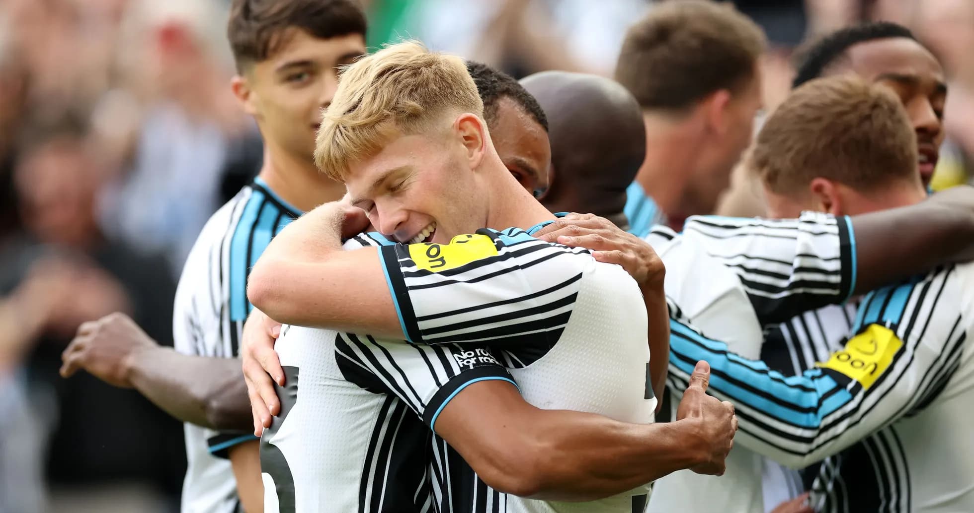 Players celebrating with hugs after a goal