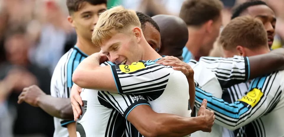 Players celebrating with hugs after a goal