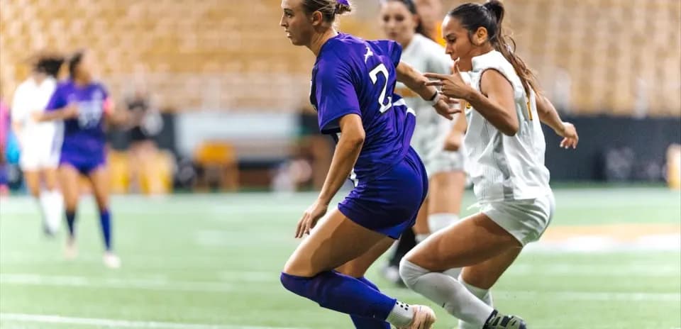 Two soccer players competing for the ball