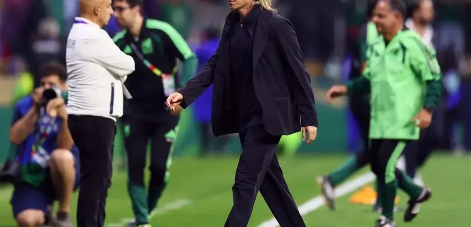Coach walking on the pitch after the match