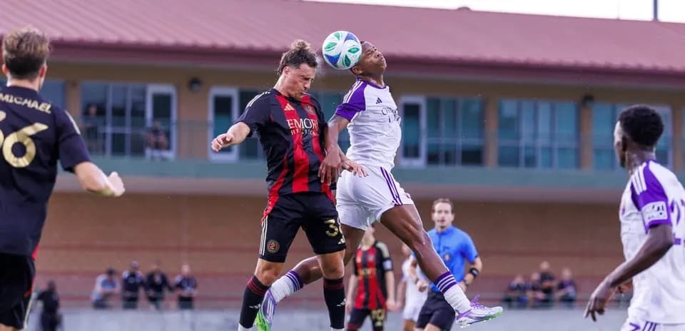 Players contesting a header during MLS Next Pro match
