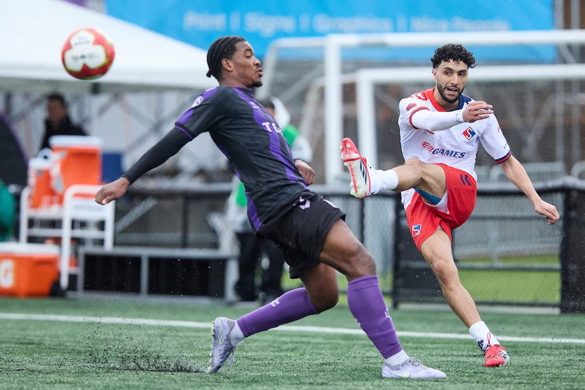Vancouver FC player kicking ball against Supra du Quebec