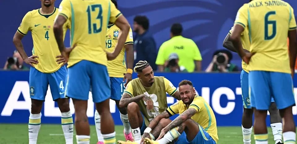 Neymar sitting on field with teammates during match