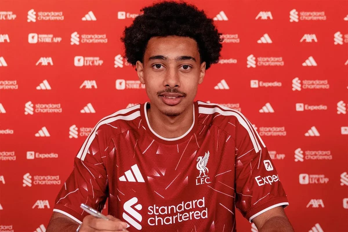Player signing contract in Liverpool FC kit