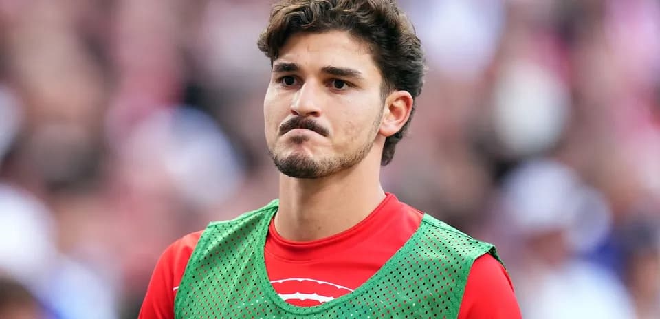 Player in training vest on sideline during match