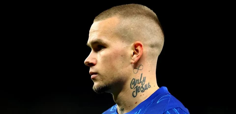 Player with tattoos in blue jersey profile view