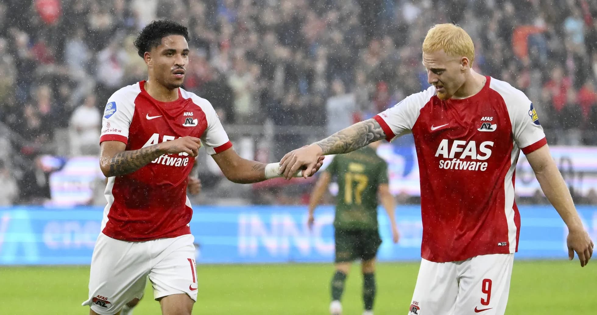 Two AZ Alkmaar players celebrating on the pitch