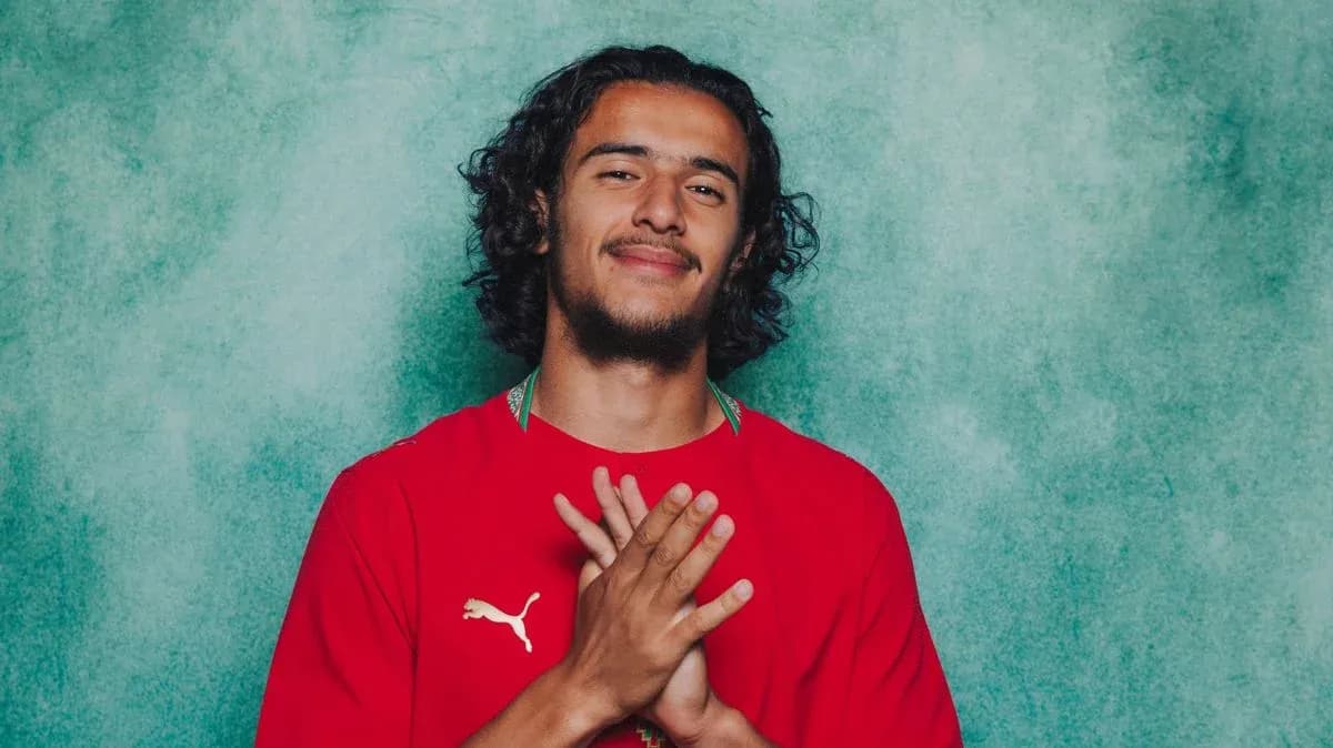 Athlete posing in red jersey with hands together