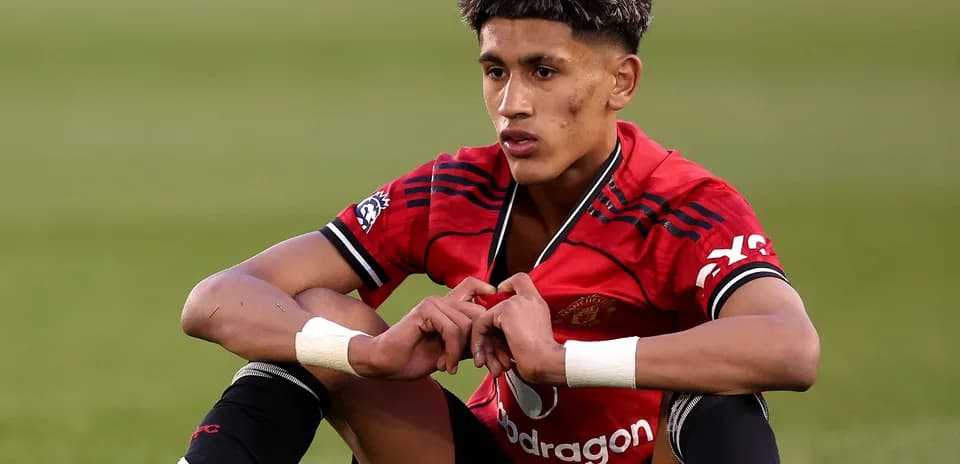 Player sitting on field in Manchester United kit