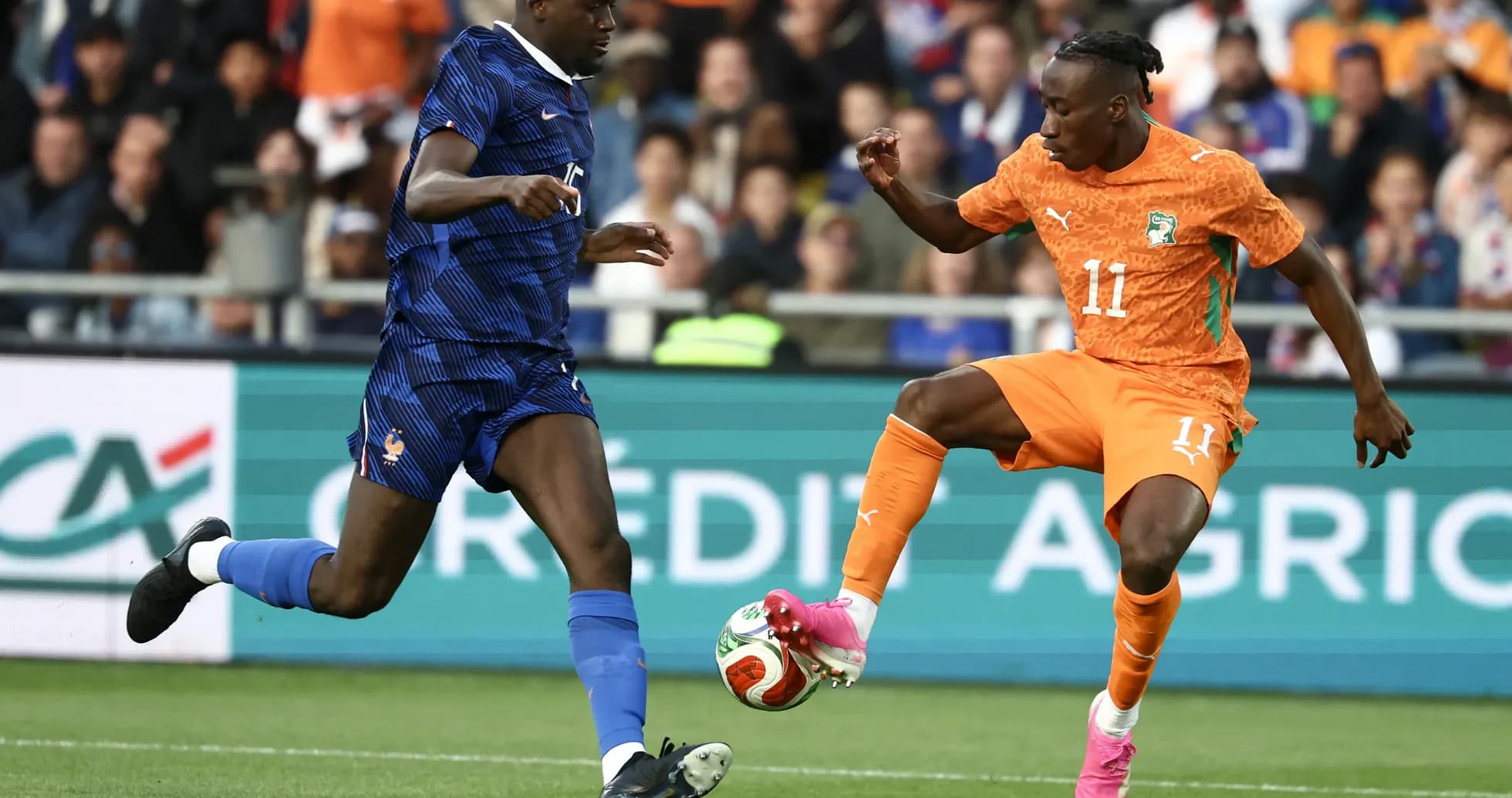 Player in orange evading tackle from player in blue