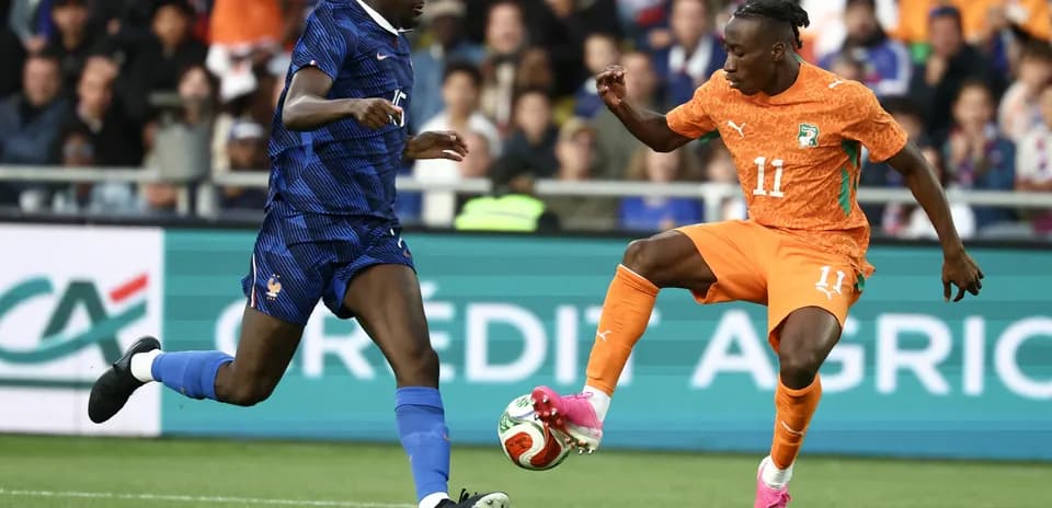 Player in orange evading tackle from player in blue
