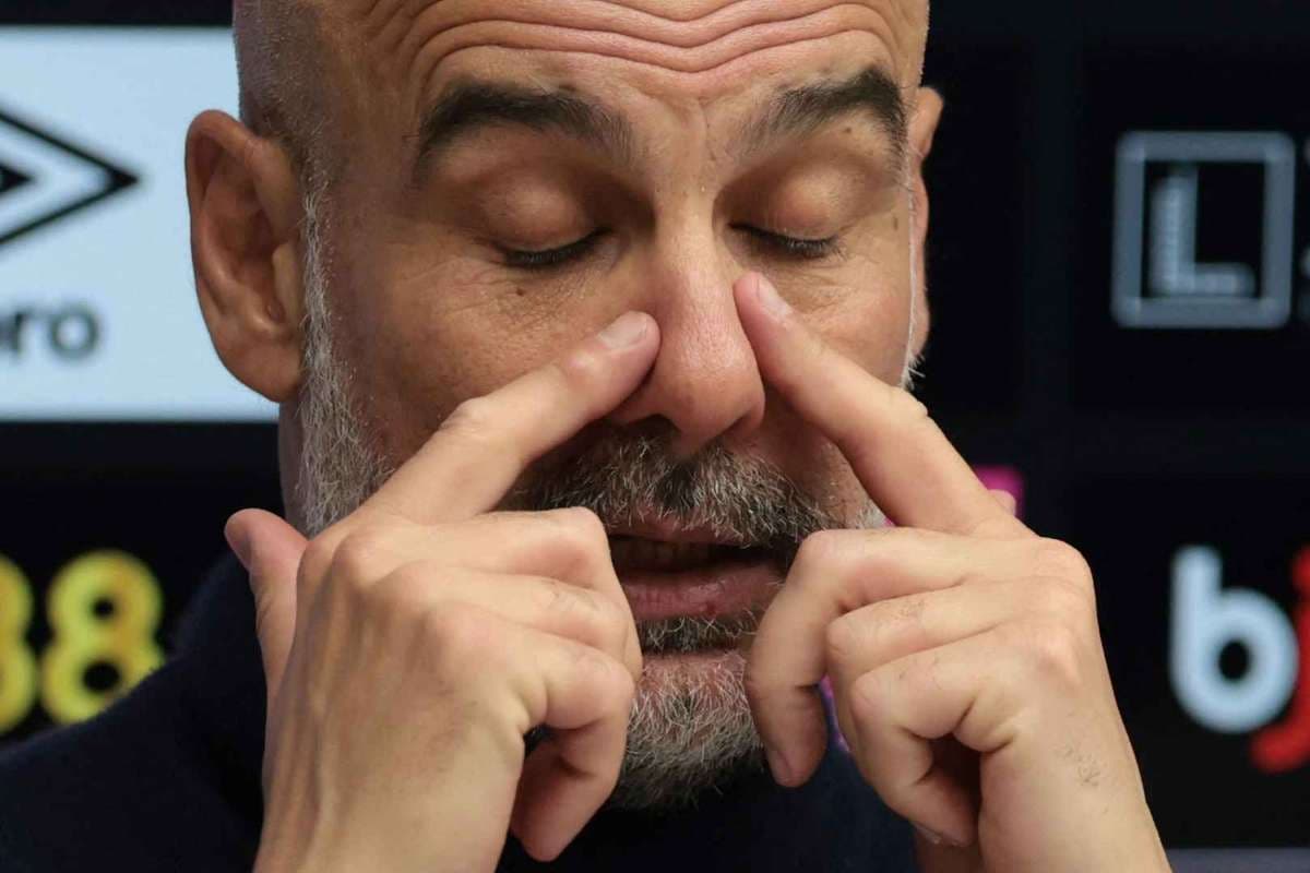 Manager gesturing during press conference with closed eyes