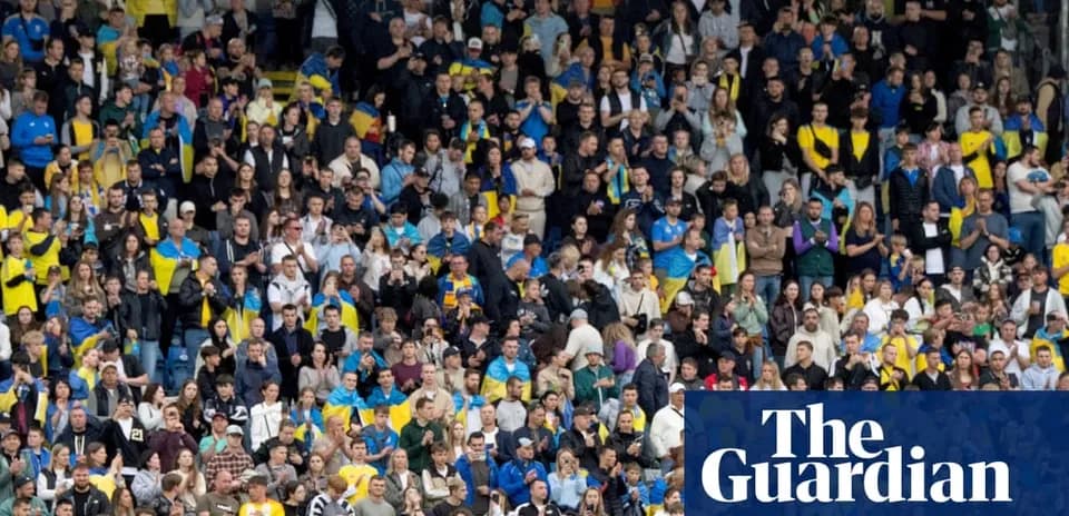Crowd of fans in stadium cheering during match
