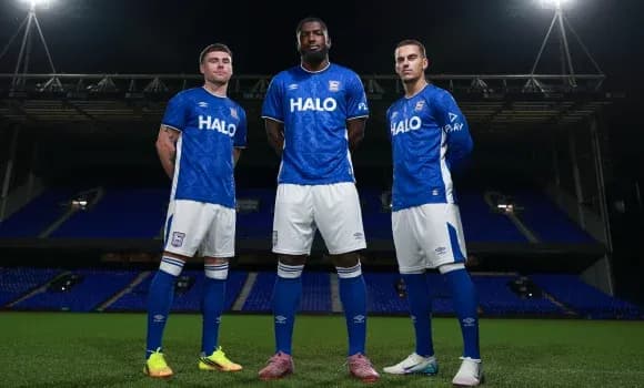 Three players in blue team jerseys on pitch