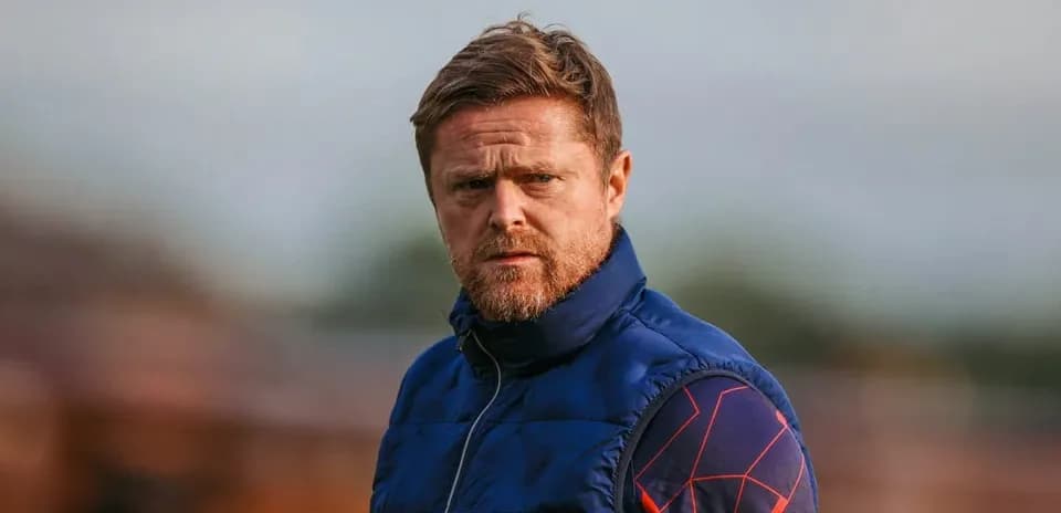 Coach observing training session on the pitch