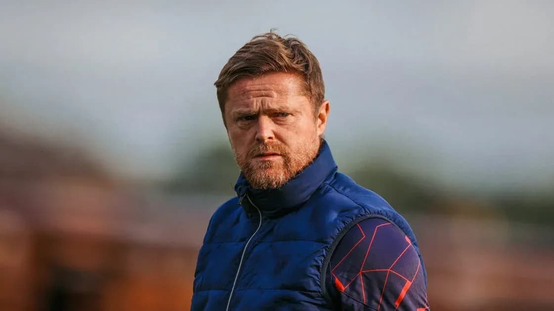 Coach observing training session on the pitch