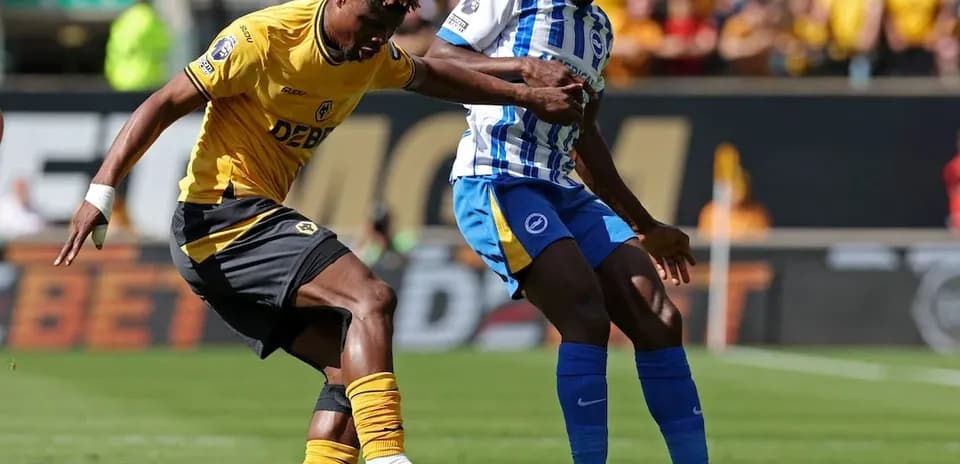 Brighton player tackling Wolves player during match