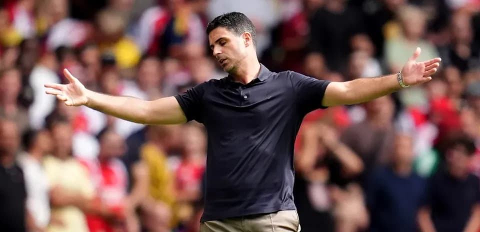 Manager gesturing during match with crowd in background