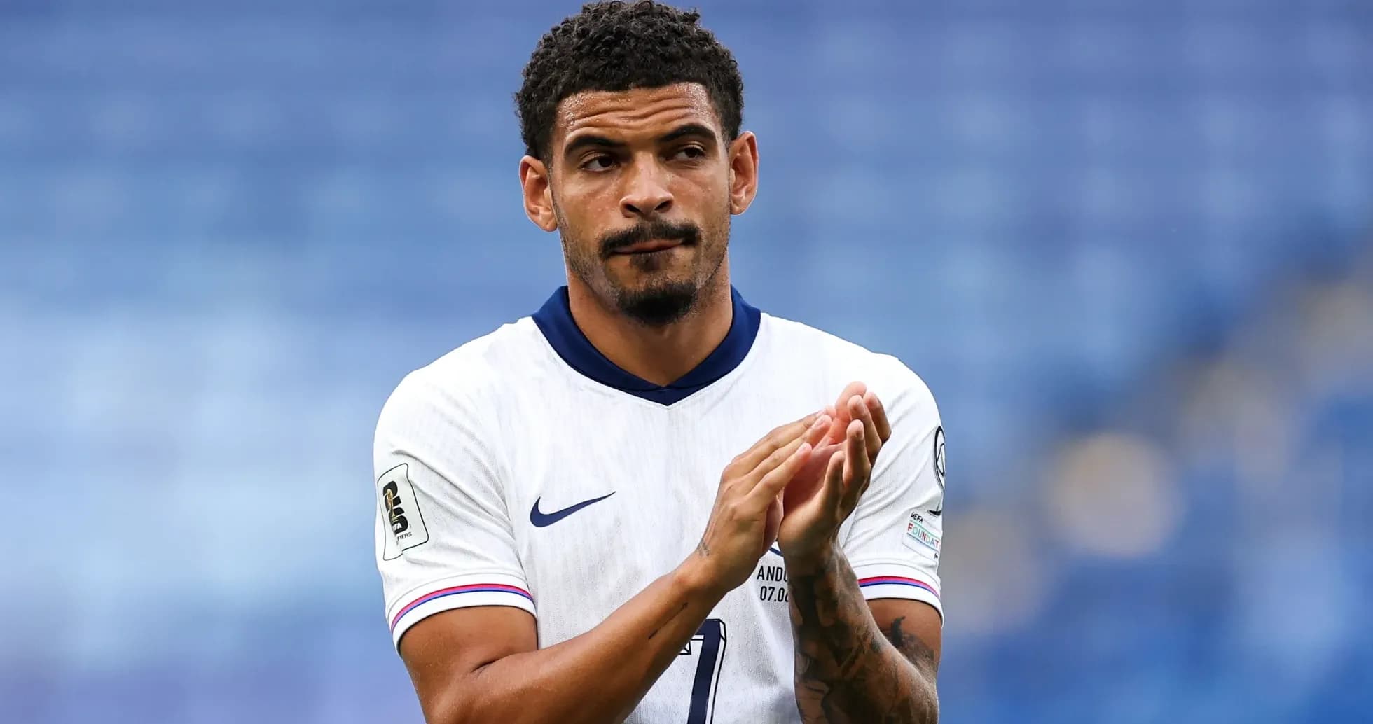 Player applauding on the pitch in team uniform