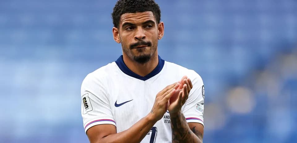 Player applauding on the pitch in team uniform