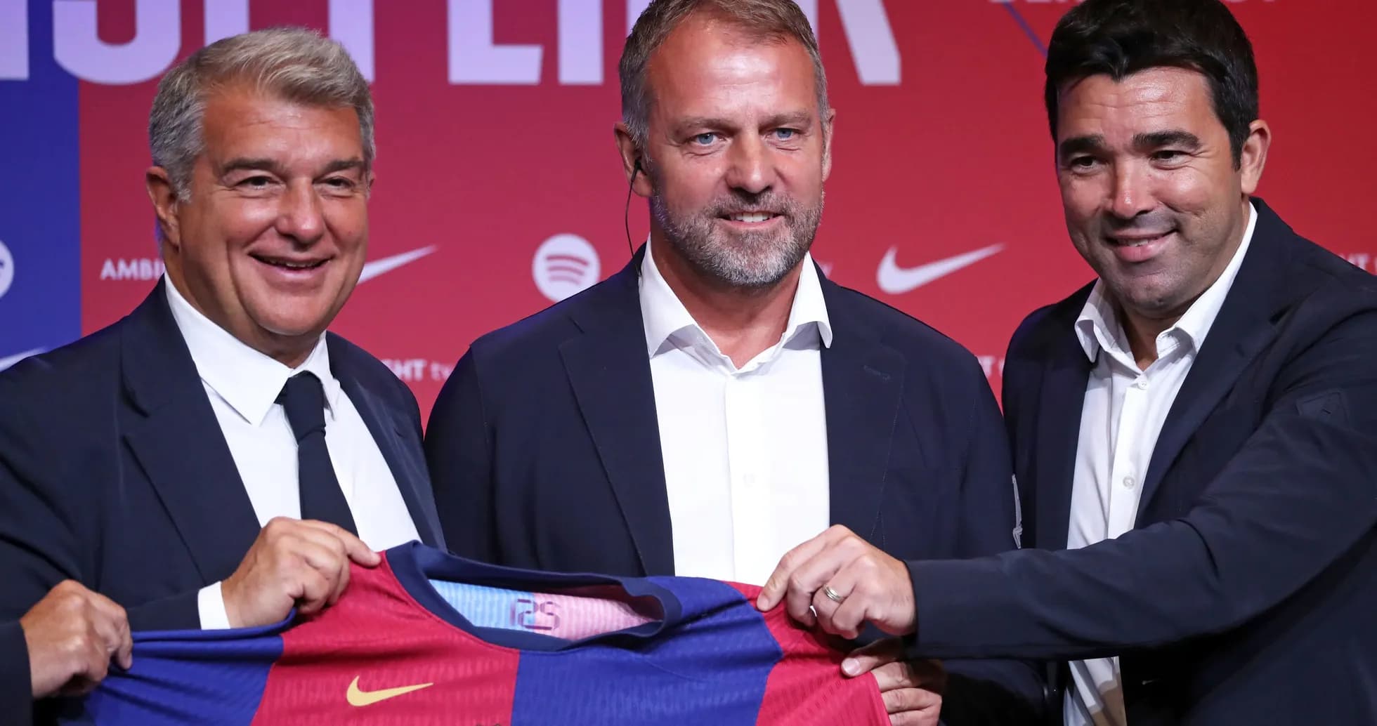 Three officials presenting a Barcelona jersey at event