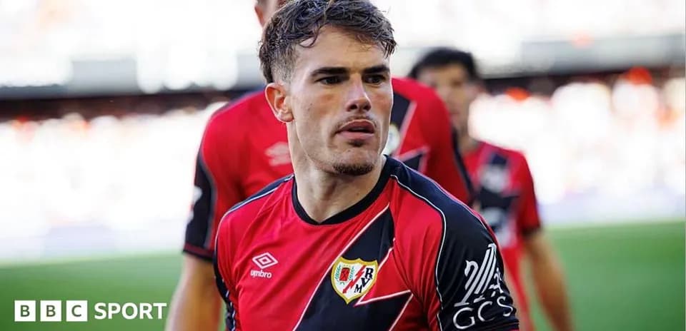 Player in red and black jersey walking onto the field