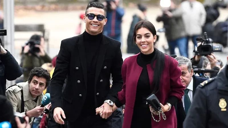 Couple walking hand in hand surrounded by photographers