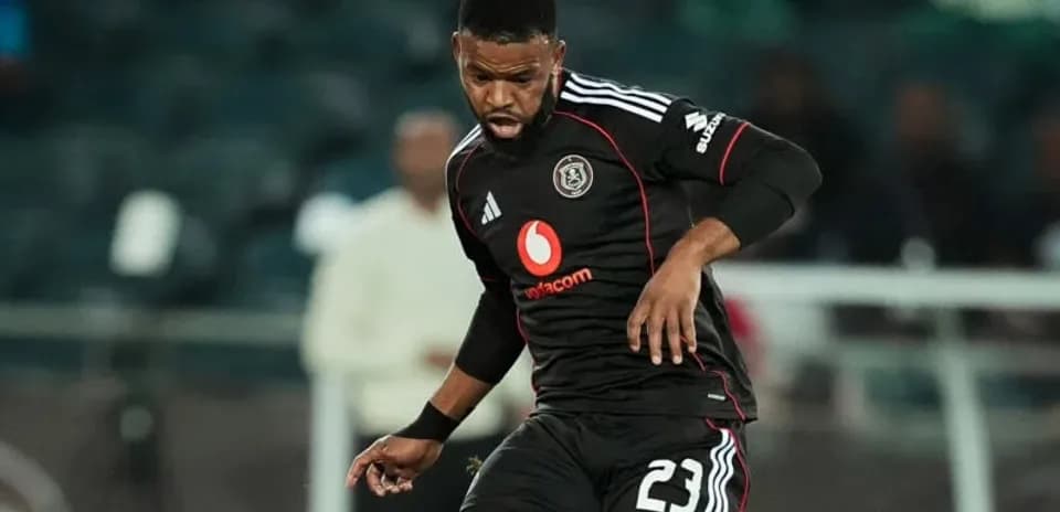 Player in black kit dribbling ball during match