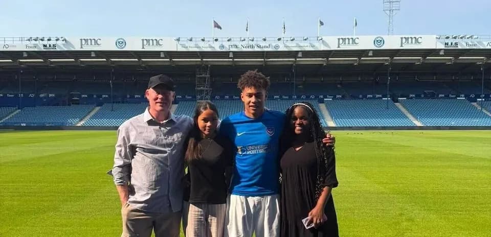 Group photo on football pitch with player in kit