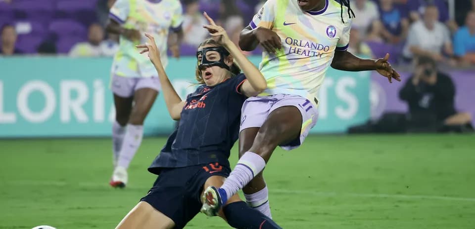Player tackles opponent during NWSL match