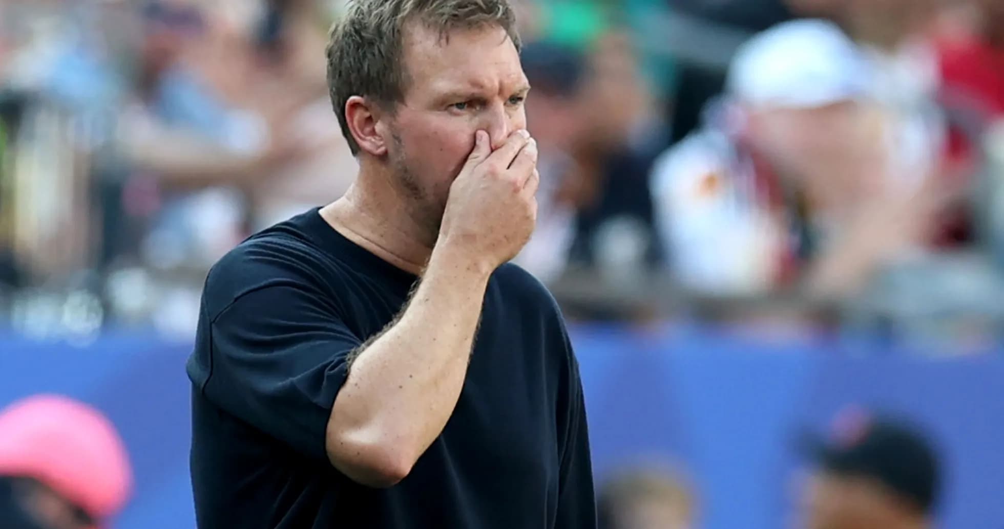 Coach observing game with hand on face