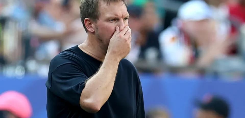 Coach observing game with hand on face