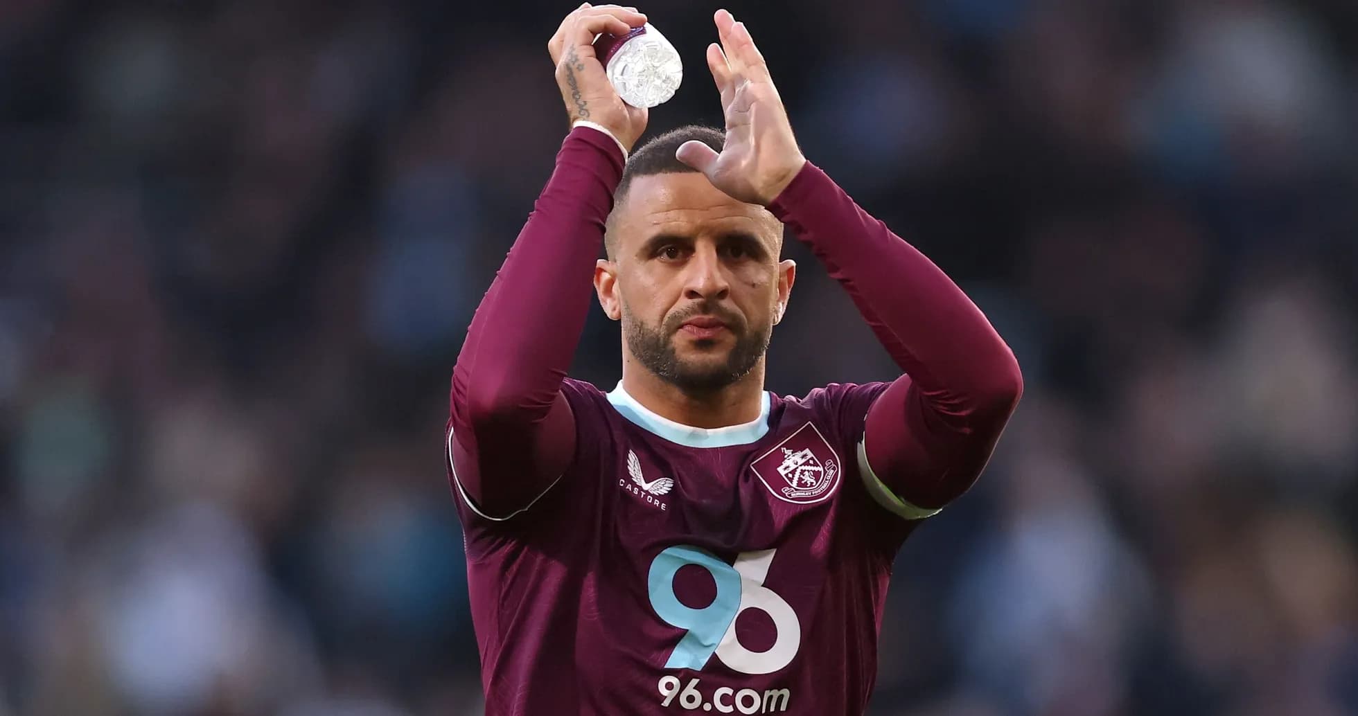 Player applauding fans while holding water bottle