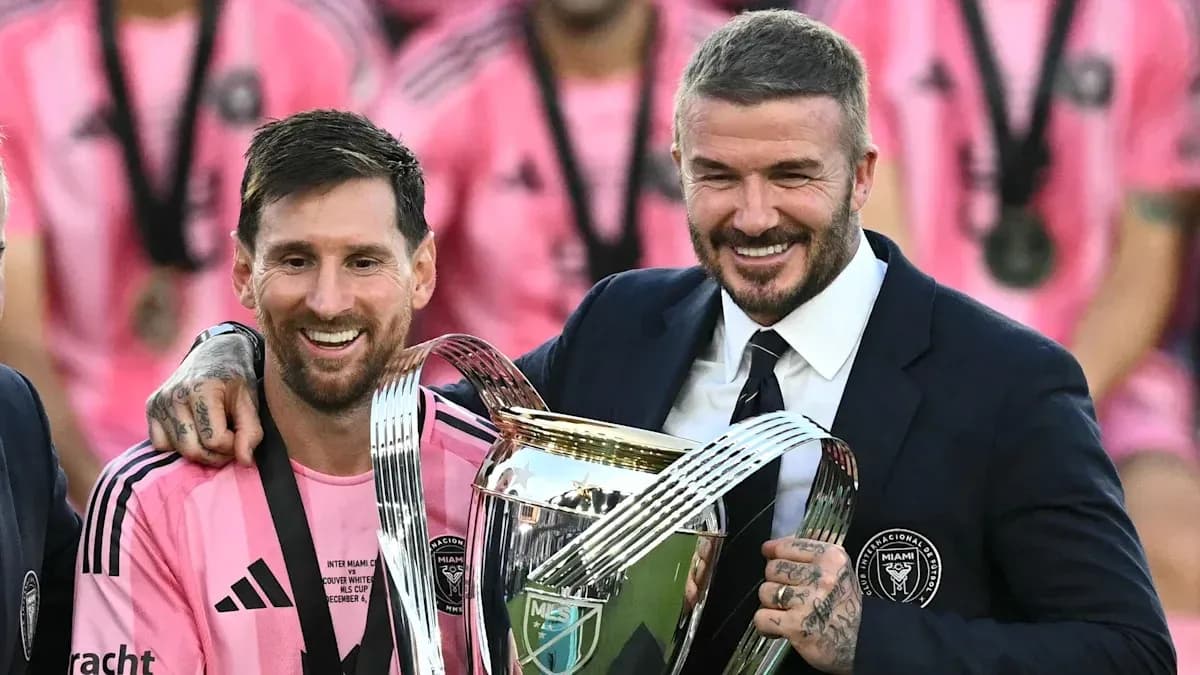 Lionel Messi and David Beckham holding trophy together