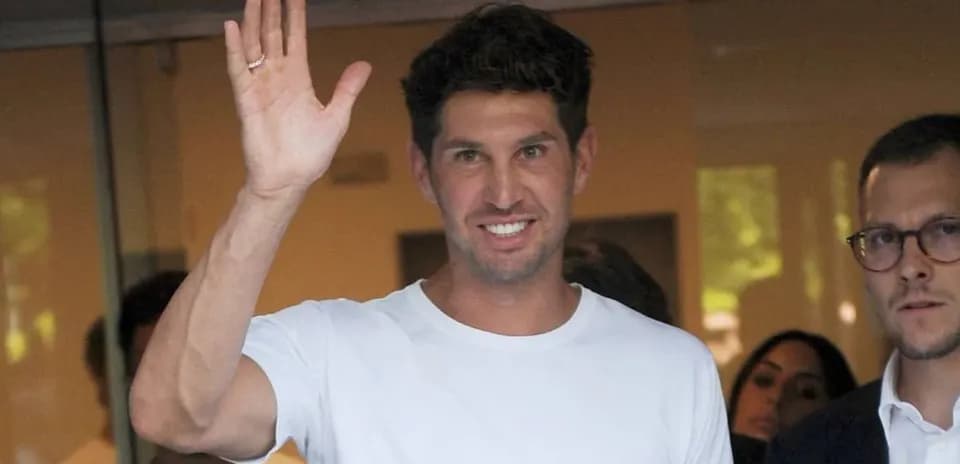Man waving while standing with others in background