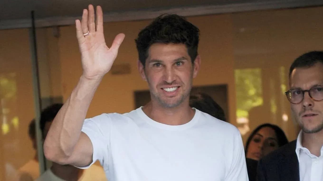 Man waving while standing with others in background