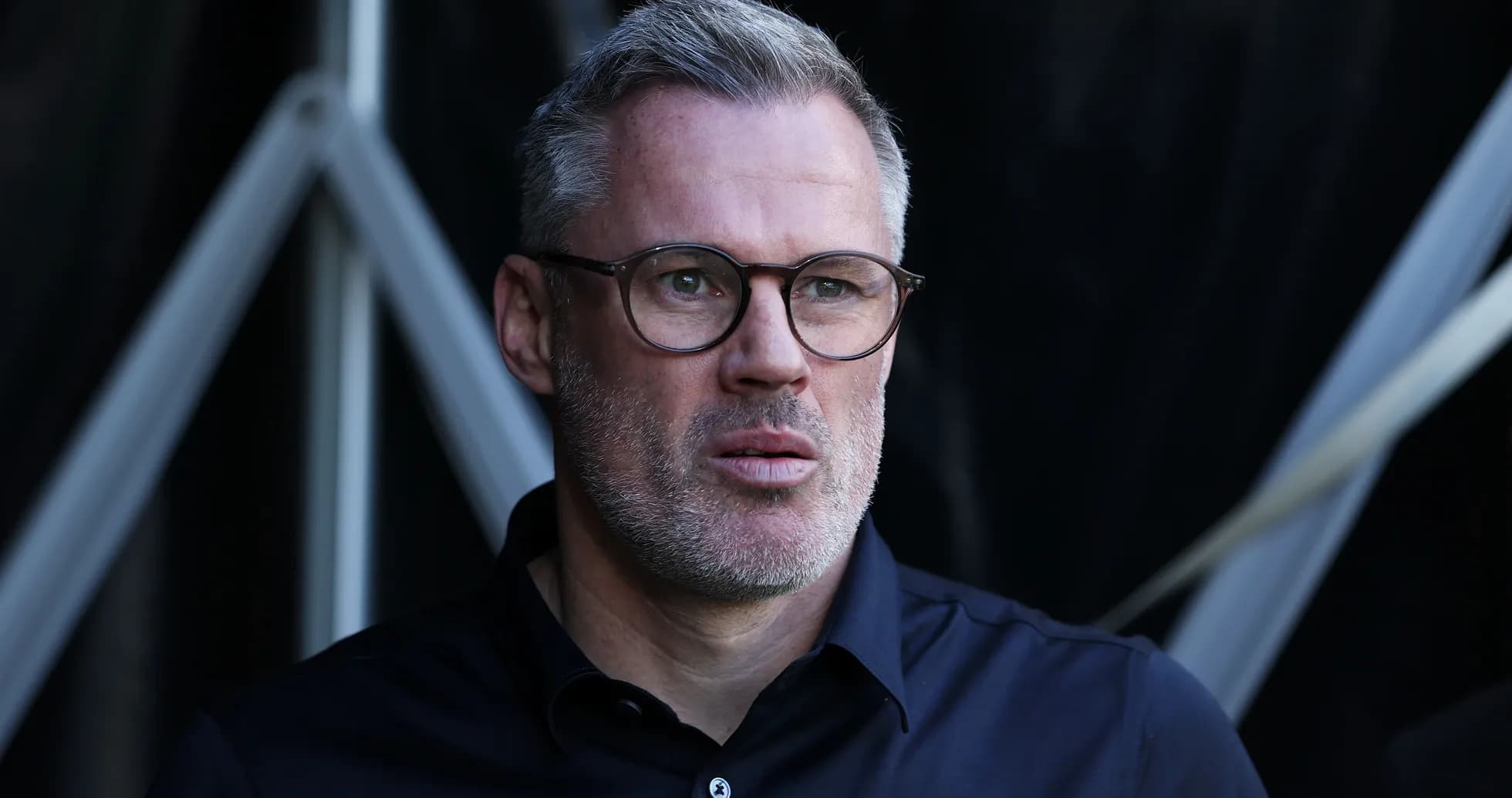 Man with glasses observing from the sidelines