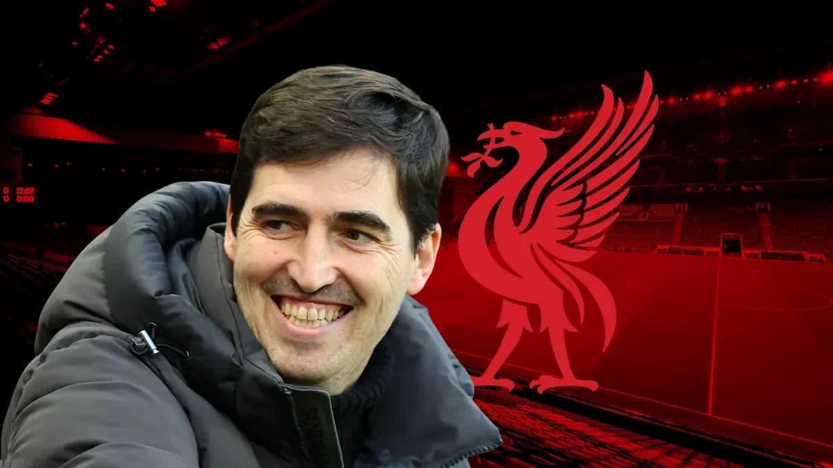 Coach smiling with Liverpool logo in background