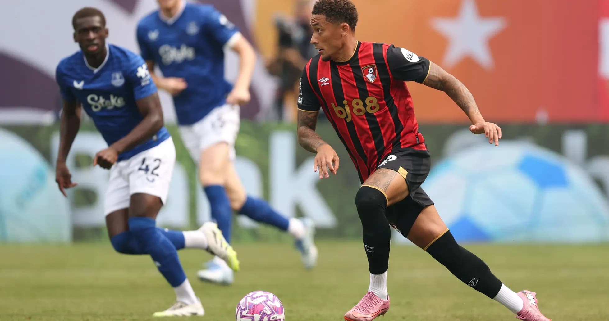 Bournemouth player dribbling past Everton defenders
