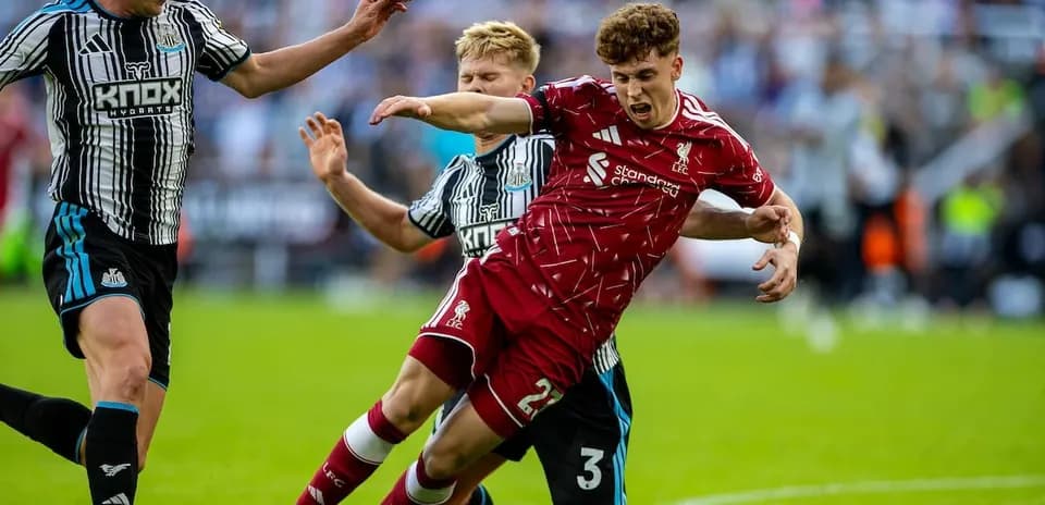 Newcastle players challenge Liverpool player for the ball
