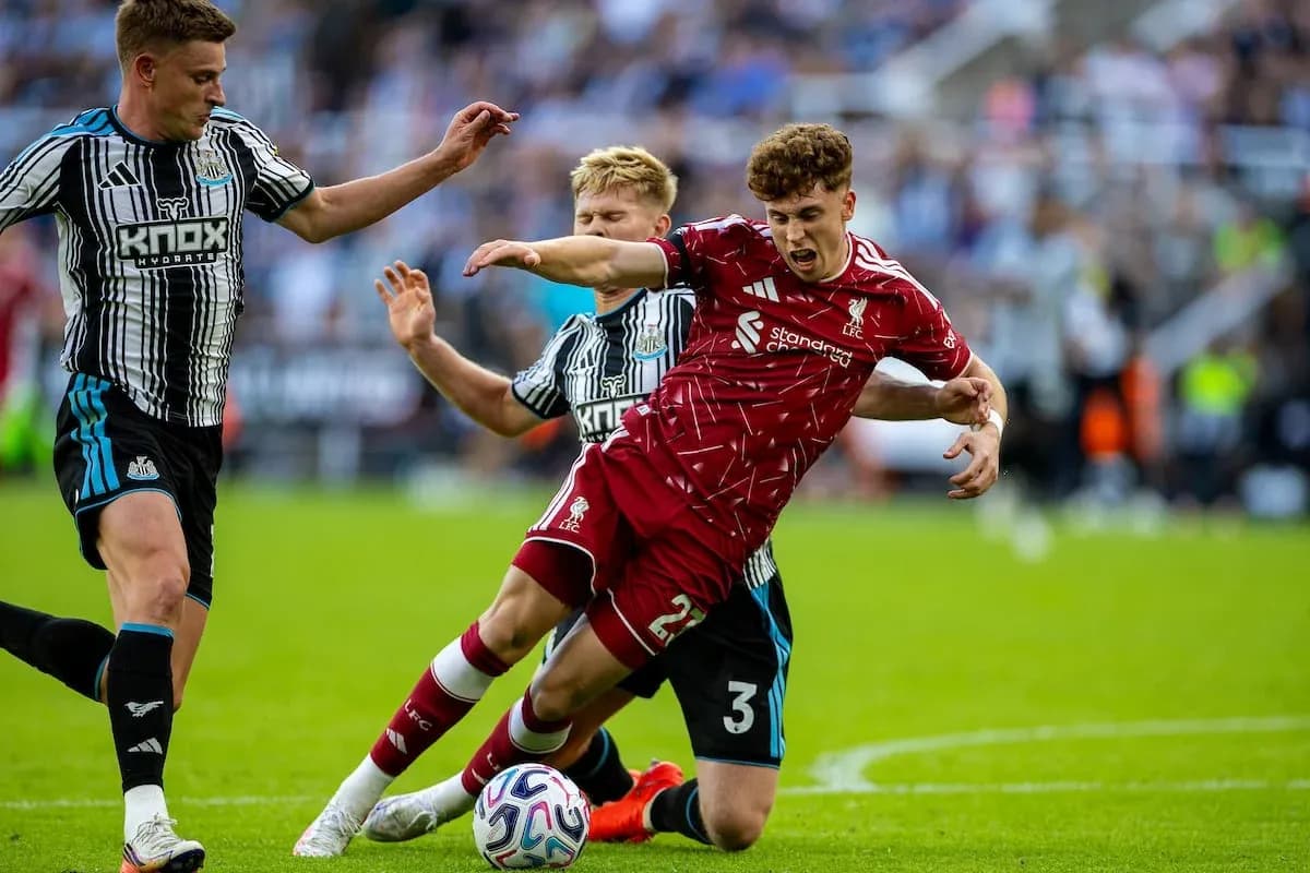 Newcastle players challenge Liverpool player for the ball